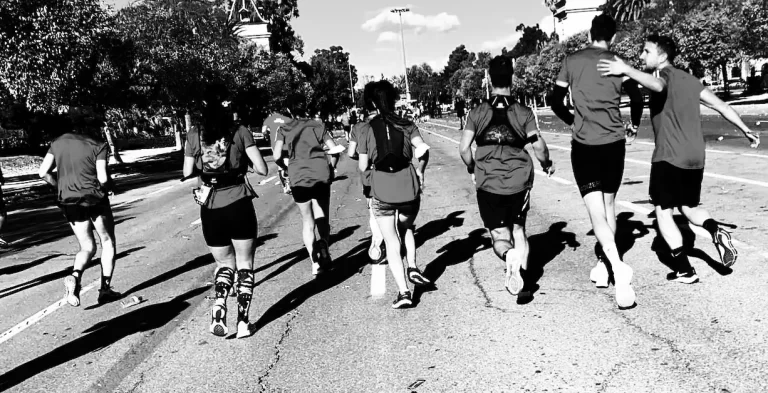 Varias personas corriendo una maratón en grupo, de espaldas a cámara